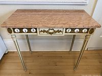 Full view of console table, showing marble top, portrait medallions, gilt trim, and legs