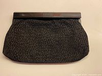 Full view of clutch showing textured suede front and handle