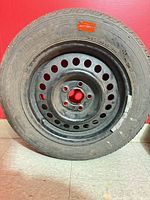 Full view of tire mounted on steel wheel showing size and overall wear
