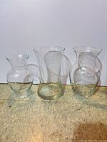 Front view of the three clear glass vases standing side by side