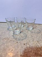 Four clear glass cups on flooring surface