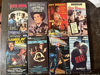All eight VHS tapes front covers visible in two rows on tabletop
