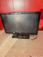 Front view of Aveis LCD TV on stand