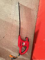 Full view of hedge trimmer showing housing, handle, blade and cord
