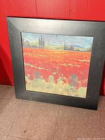 Front view of framed landscape print against red wall