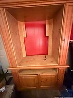 Full view of wooden corner TV stand with large open compartment and lower cabinet