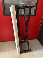 Bench on side showing black painted wood frame and full upholstered seat