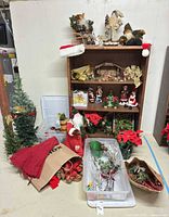 Overall lot with bookcase, figurines, trees, poinsettias, greenery and storage bins