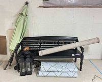 Lot overview showing bench, rugs, umbrella, lanterns