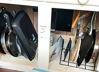 Cabinet left side showing multiple pans and griddle in rack