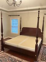 Assembled king four-poster bed frame with box springs in room