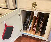 Open cabinet showing divider insert with cutting boards and pans