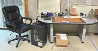 Desk, chair, shredder, box of paper shown together