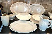 Overall lot showing all nine porcelain pieces on stovetop