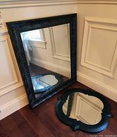 Rectangular and quatrefoil mirrors leaning against wall