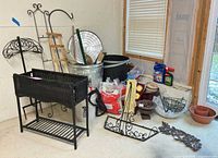 Overall lot showing wicker planter, metal stands, trash can, soil bags, décor pieces