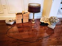 Lot overview showing lamp with shade, boxes, urn, plaque, bird, extended power cord