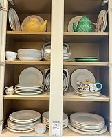 cabinet view showing plates, teapots, trays