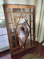 Front view of rectangular wood-framed mirror with diamond muntin