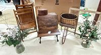 Front view showing folding chairs, desk, wicker basket on wheelbarrow frame, round hat box and faux eucalyptus arrangements