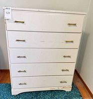 Front view of white five-drawer dresser showing all drawers and handles