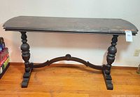 Front view of dark wood console table showing legs and stretcher