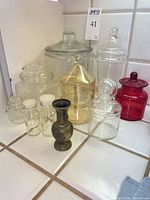 Group shot of all glass jars and metal vase