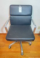 Front view showing black vinyl cushions, chrome arms, five-star base with casters