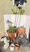 Group view of planters, stakes, statue, clock, baskets