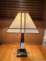 Full view of lamp illuminated showing shade, base, pull chains, and power cord