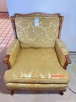 Angled front view showing gold damask upholstery and wooden frame