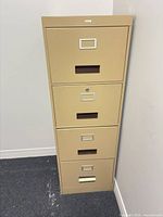 Front view showing four drawers, pulls, label holders and lock