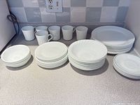 Overall view of Corelle plates, bowls and cups on counter