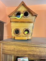 Front angled view showing roof, four openings, one attached bird