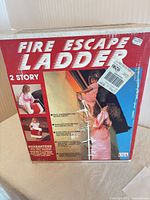 Front of boxed Dial Safety Ladder Corp 2-story fire escape ladder showing product imagery and branding