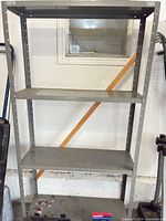 Full view of gray steel shelving unit with four shelves