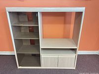 Front view of cabinet showing glass-door shelving, open compartment, shelf, and lower two-door storage