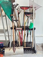 Full view of tool rack with assorted long-handle tools