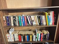 Full view of two bookshelf rows showing majority of the 63 mixed-format books