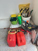 Group shot showing hedge trimmer, gas cans, spreaders, funnel, soil/salt bags, pail of tools
