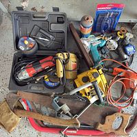 Overview of assorted power tools, hand tools, discs and propane canister