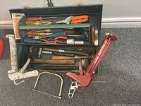 Overview of toolbox and hand tools including caulking guns, hacksaw and mallet