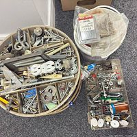 Overview of round tray, bucket, rectangular box showing mixed hardware and electrical parts