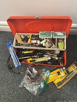 Closed view of open red toolbox showing contents and packaged items