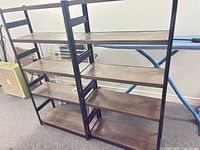 Front view of both matching shelving units showing five shelves each