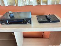 Both Panasonic VCR and Philips DVD player with remotes on top
