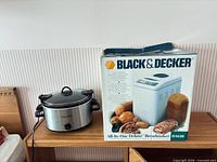 Crock-Pot slow cooker and boxed breadmaker on shelf