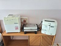All three countertop appliances side by side on shelf