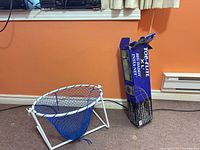 Collapsed frame with blue net inside next to box