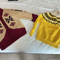 Both sweaters laid flat showing overall design and colors